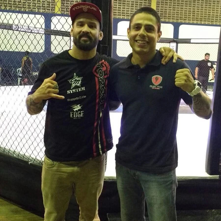 Anderson Hickman ao lado de outro profissional próximo ao octógono