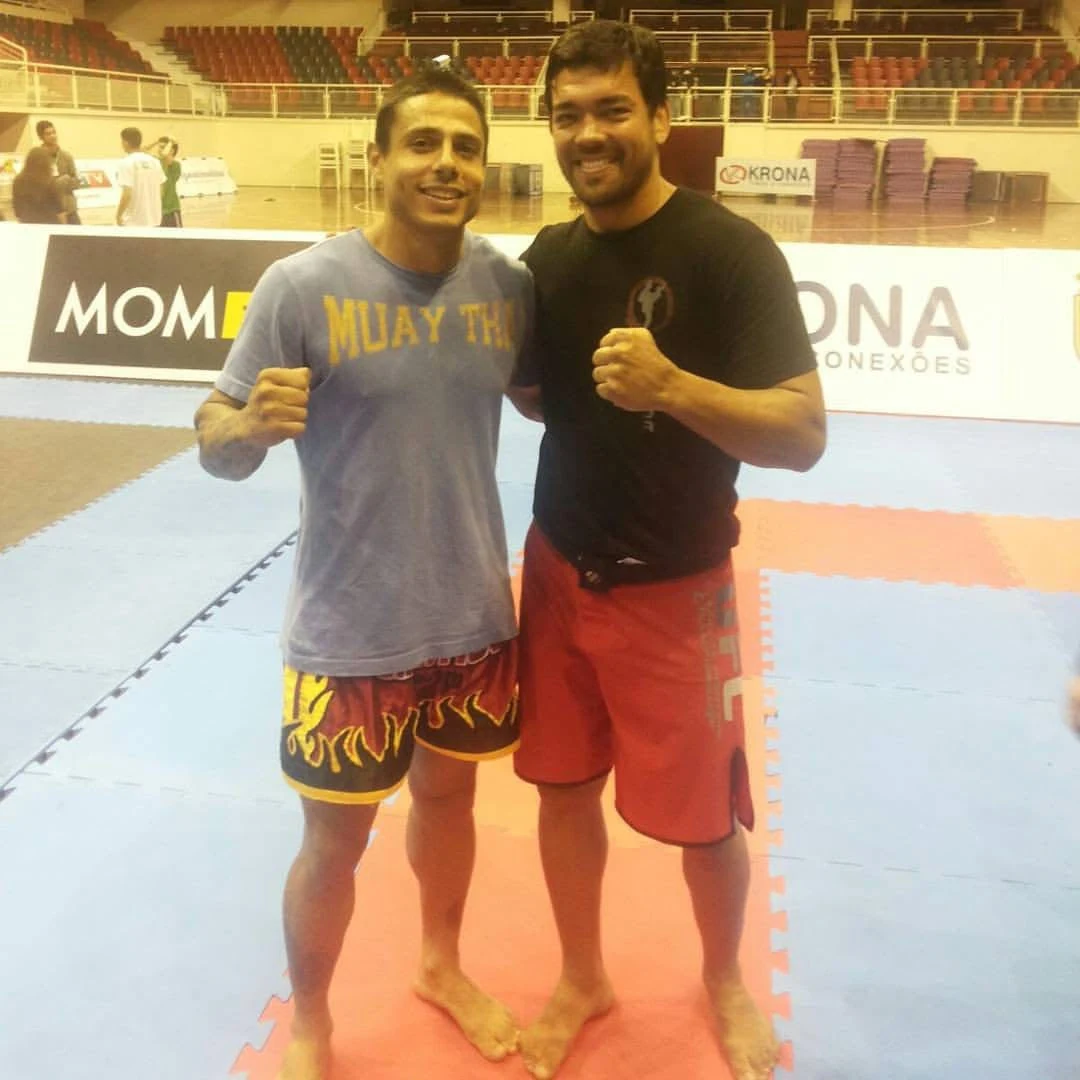 Anderson Hickman ao lado de outro atleta em ginásio esportivo durante evento